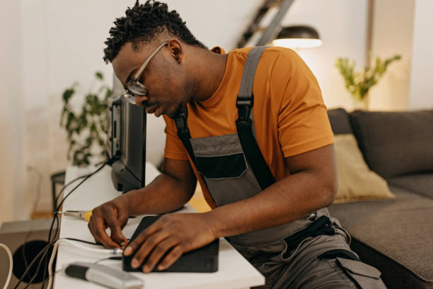 Young handyman fixes cable tv